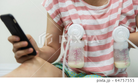 Mom pump breastmilk and play phone 64757555