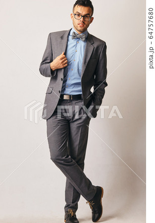 Full length portrait of a young businessman standing with his hands in the pockets. 64757680