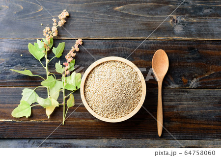 Organic raw brown quinoa seed in a bowl with spoon and quinoa plant on wooden background, Healthy eating, Top view 64758060