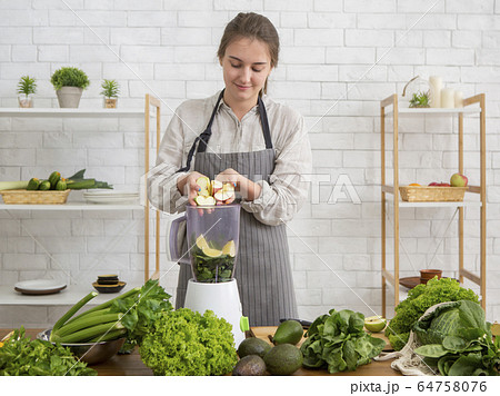 Young woman preparing detox smoothie in blender 64758076