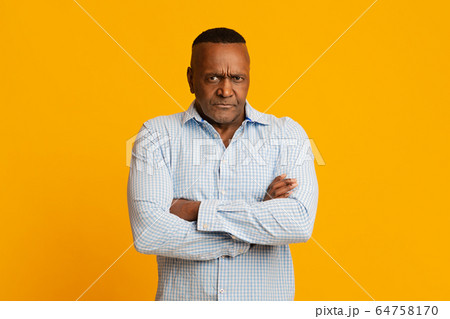 Grumpy mature african american man looking at camera Grumpy mature african american man looking at camera 64758170