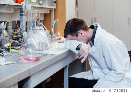 Male scientist sleeps in medical chemical lab 64759831