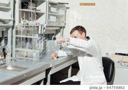 male scientist conducts chemical experiments in medical laboratory male scientist conducts chemical experiments in medical laboratory 64759862