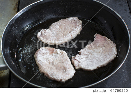Cooking chops in a pan shot close-up. 64760330
