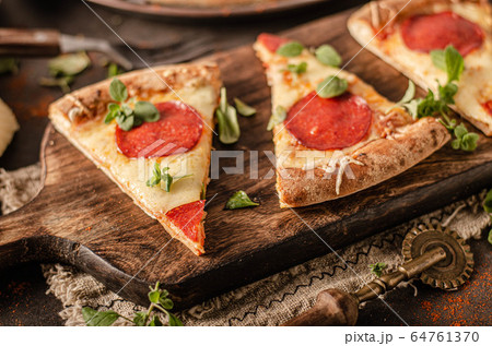 Homemade salami pizza with cheese corners Homemade salami pizza with cheese corners 64761370