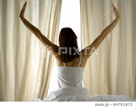 Woman stretching in bed after waking up, back view, entering a day happy and relaxed after good night sleep. Good morning and new day for brunette. Concept of Weekend, holidays Woman stretching in bed after waking up, back view, entering a day happy and relaxed after good night sleep. Good morning and new day for brunette. Concept of Weekend, holidays 64761872