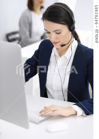 Call center. Beautiful woman sitting and working in headset at customer service office. Business concept 64761985