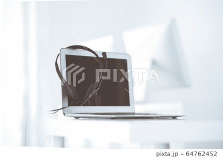 Call center and communication support, customer service help desk. VOIP headset on laptop computer Call center and communication support, customer service help desk. VOIP headset on laptop computer 64762452