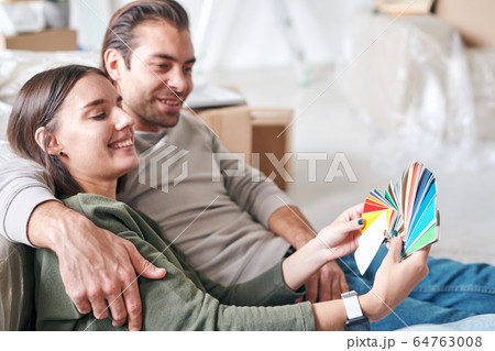 Happy young woman with toothy smile showing her husband color palette 64763008