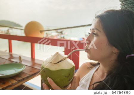 Portrait of young caucasian woman drinking fresh 64764390