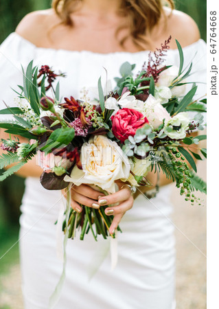 Close-up bouquet of flowers in women's hands. style, floral arranging, wedding concept. Close-up bouquet of flowers in women's hands. style, floral arranging, wedding concept. 64764668
