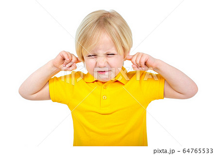 Annoyed boy covers his ears with fingers Annoyed boy covers his ears with fingers 64765533