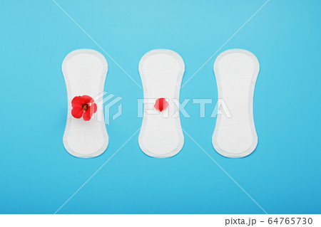 Three Sanitary pads on a blue background. The 64765730