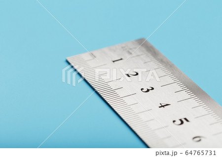 Metal ruler on a blue background close-up with a Metal ruler on a blue background close-up with a 64765731