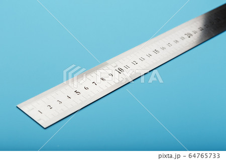 A metal ruler with a scale on a blue background is A metal ruler with a scale on a blue background is 64765733