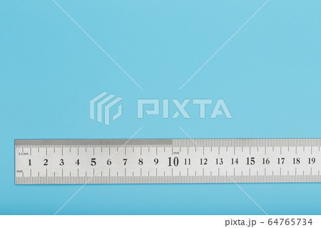 A metal ruler with a scale on a blue background is A metal ruler with a scale on a blue background is 64765734