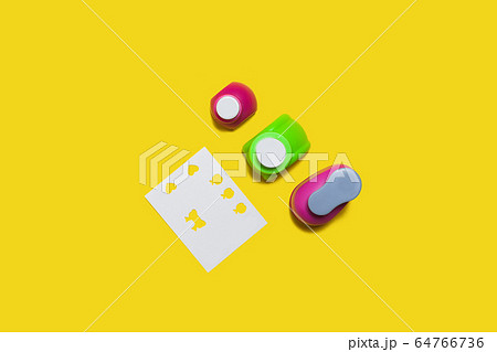 row of hole punchers near a paper 64766736