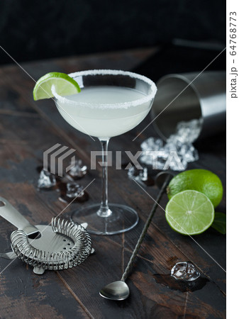 Glass of Margarita cocktail with fresh limes and Glass of Margarita cocktail with fresh limes and 64768773