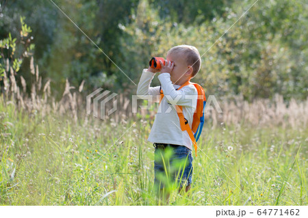 Young explorer watching with binoculars of birds Young explorer watching with binoculars of birds 64771462