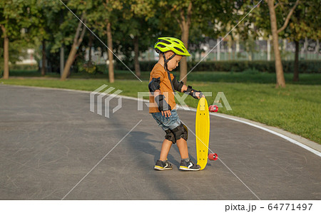 A little boy enjoys a yellow cruiser penny 64771497