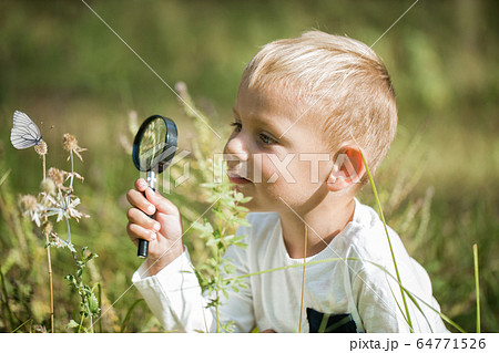 Young researcher explores nature with a magnifying Young researcher explores nature with a magnifying 64771526