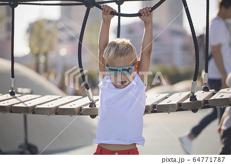 A boy plays on a rope bridge A boy plays on a rope bridge 64771787