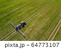 tractor spraying herbicides on field, Tractor Spraying Chemicals on Field - GMO Crops. 64773107
