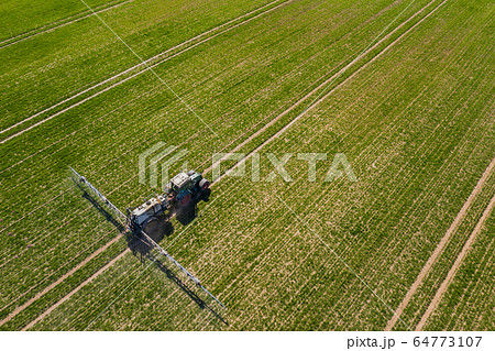 tractor spraying herbicides on field, Tractor Spraying Chemicals on Field - GMO Crops. tractor spraying herbicides on field, Tractor Spraying Chemicals on Field - GMO Crops. 64773107