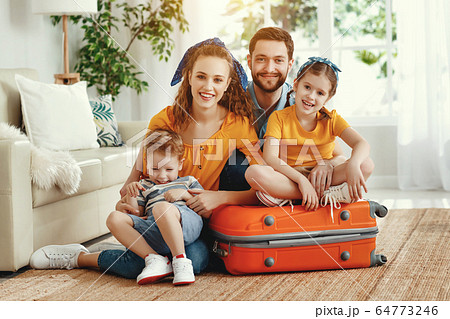 Cheerful family with suitcases on floor looking at Cheerful family with suitcases on floor looking at 64773246