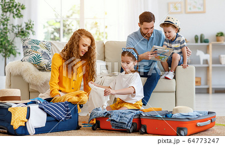 Family preparing for vacation while packing on 64773247