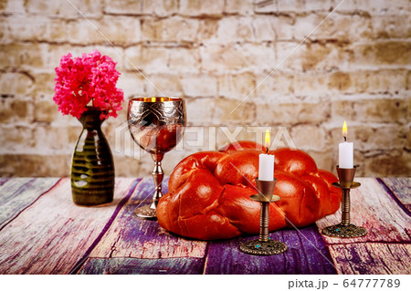 Shabbat candles in candlesticks of loaves challah 64777789