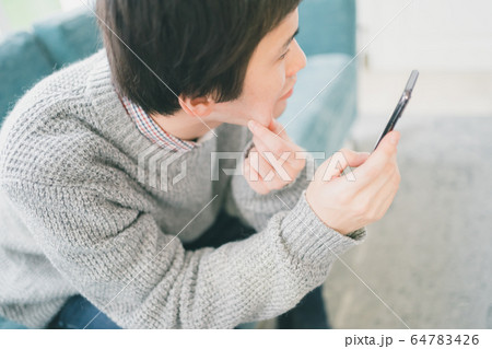 スマホ　男子学生 64783426