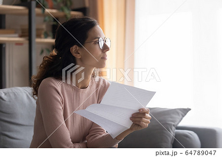 Thoughtful young attractive woman in glasses planning payout. Thoughtful young attractive woman in glasses planning payout. 64789047