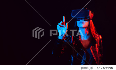 girl in 3D virtual reality glasses touches the projection screen with her finger girl in 3D virtual reality glasses touches the projection screen with her finger 64789490