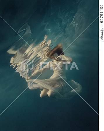 Girl in a sequined dress swims underwater Girl in a sequined dress swims underwater 64791436