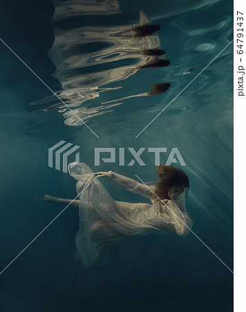 Girl in a sequined dress swims underwater Girl in a sequined dress swims underwater 64791437