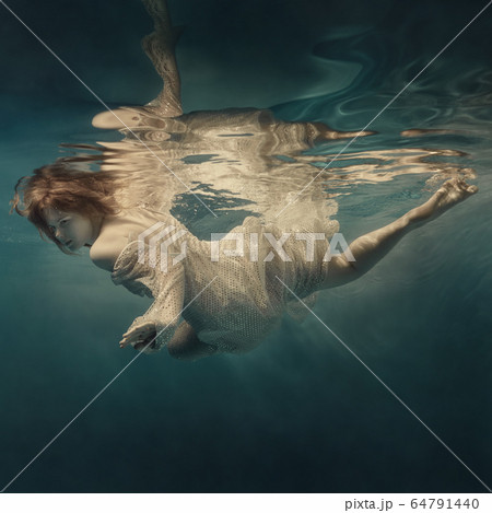 Girl in a sequined dress swims underwater Girl in a sequined dress swims underwater 64791440