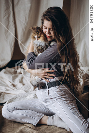 Girl communicates with her domestic red fluffy cat. Love for animals. 64791800