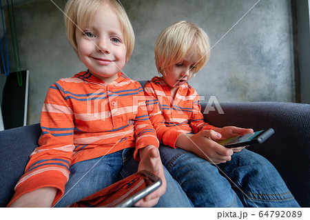 Brothers are watching or playing or learning something in a smartphone Brothers are watching or playing or learning something in a smartphone 64792089