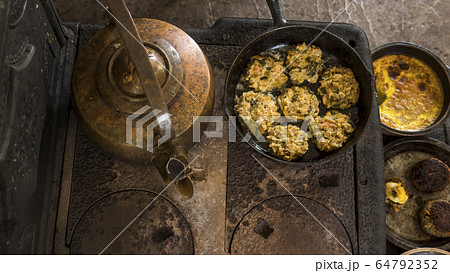 An ancient stove with a kettle and a frying pan in an American house 64792352