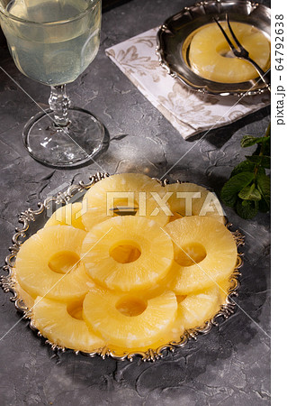 Canned pineapple, cut into rings on a metal plate Canned pineapple, cut into rings on a metal plate 64792638