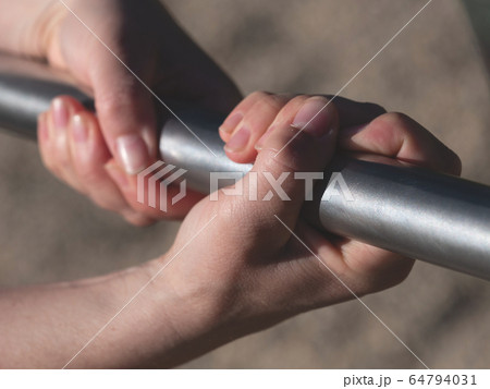 Girls hands holding on blue steel in outdoor 64794031