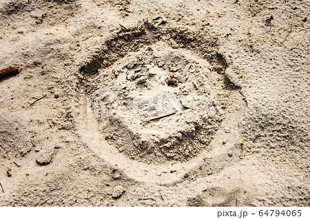 Sad or unhappy face drawn on sand at beach. Sad or unhappy face drawn on sand at beach. 64794065