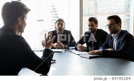 Three attentive hr manager listening to job candidate at meeting Three attentive hr manager listening to job candidate at meeting 64795204