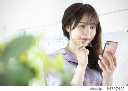 若い女性・ポートレート・スマートフォン 64797492