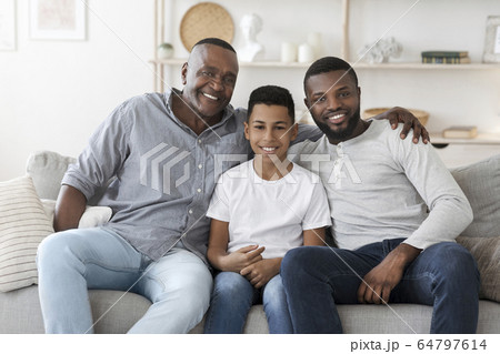 Portrait of smiling millennial black dad, son and grandfather at home 64797614
