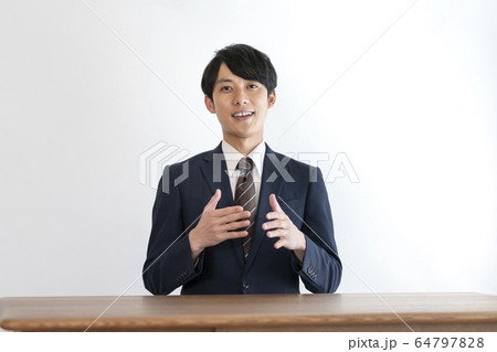 話をするスーツ姿の若い男性　 64797828