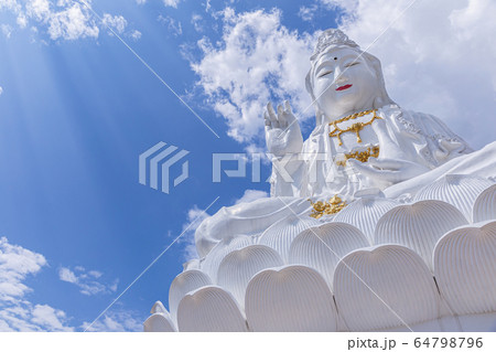 Guan Yin statue with blue sky and clouds sky at Huay Pla Kang Temple, Chiangrai, Thailand. Guan Yin statue with blue sky and clouds sky at Huay Pla Kang Temple, Chiangrai, Thailand. 64798796