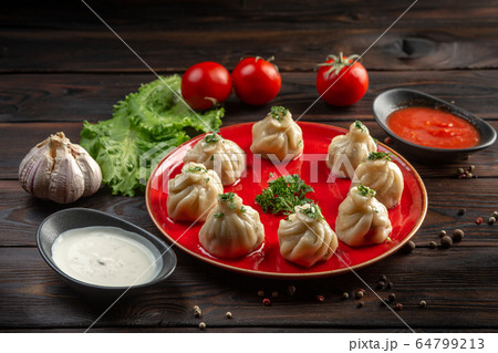 gedza with beef on a red plate and sauce in a cup gedza with beef on a red plate and sauce in a cup 64799213