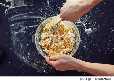 Unrecognizable male cook stirs the filling for the cake, close-up Unrecognizable male cook stirs the filling for the cake, close-up 64802088